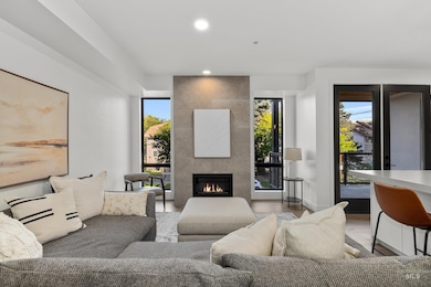 Living area with recessed lighting, plenty of natural light, a tiled fireplace, and light wood-type flooring