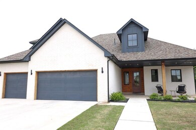 View of front facade with a garage, roof with shingles, driveway, and a porch