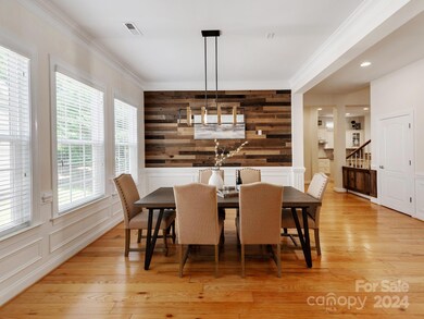 Formal dining room with feature wall and upgraded light fixture.