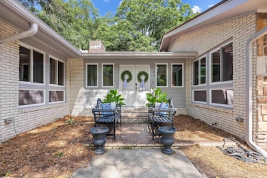 Doorway to property featuring a patio area, brick siding, and a chimney