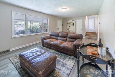 Natural light fills the living room. Shows hallway to upper bedrooms.