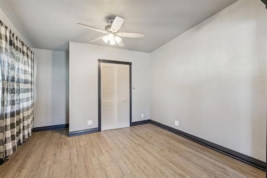 Unfurnished bedroom featuring light wood finished floors, a ceiling fan, and a closet