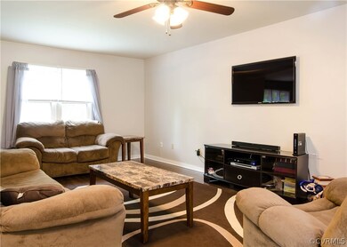 The living room has dark laminate flooring, a coat
