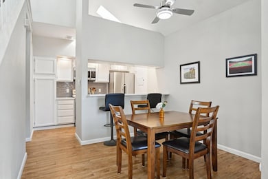 Dining space with lofted ceiling with skylight, ba