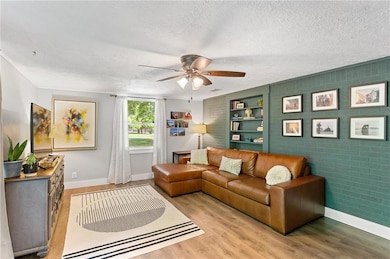Living area featuring ceiling fan, baseboards, lig