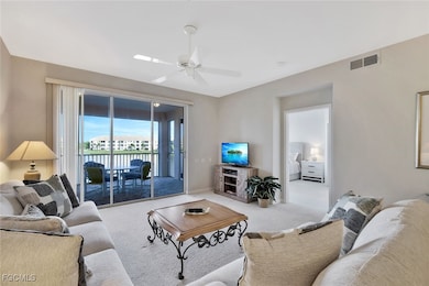 Carpeted living room featuring ceiling fan