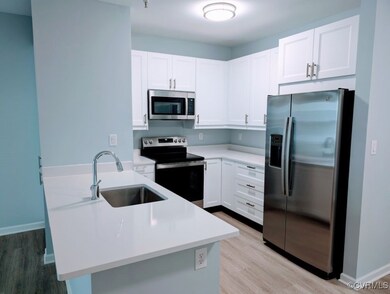 Kitchen featuring white cabinetry, light hardwood