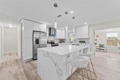 Stunningly renovated kitchen featuring all-new appliances and a sleek waterfall island centerpiece