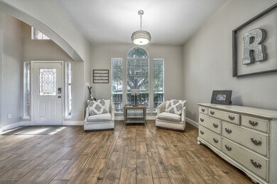 Living area featuring plenty of natural light, arched walkways, and dark wood-style floors