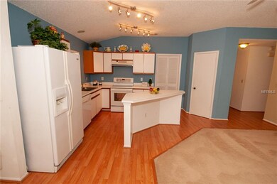 Open kitchen with laminate floors, island for bar 