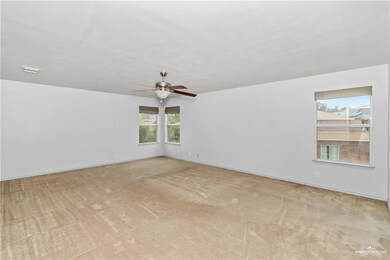 Empty room with light colored carpet and ceiling fan