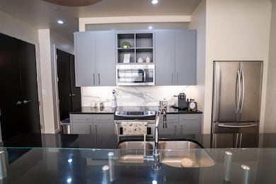 Kitchen featuring gray cabinetry, backsplash, and 