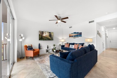 Living room with ornamental molding, light tile patterned floors, and ceiling fan