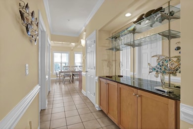Bar featuring ornamental molding and light tile pa