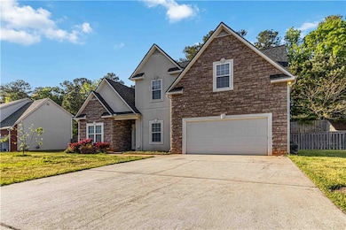 View of front of home featuring driveway, stone si