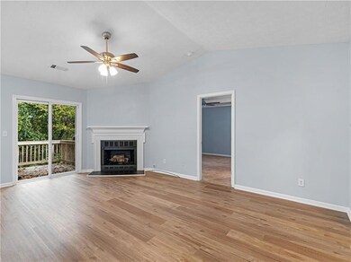 Unfurnished living room with vaulted ceiling, a fireplace, light wood-style floors, and ceiling fan