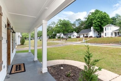 View of green lawn featuring a porch and a residential view
