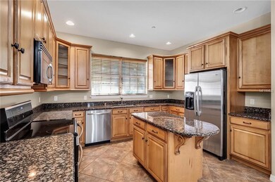 Large kitchen with wood cabinets, granite and stai