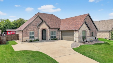 View of front of house featuring stone siding, a shingled roof, brick siding, concrete driveway, and an attached garage