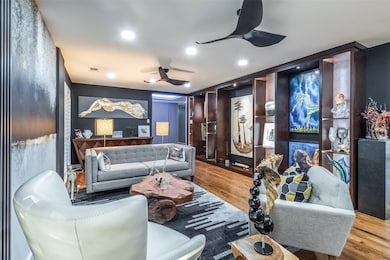 Formal living area looking toward the foyer, featuring custom built-in shelving displays and sophisticated architectural accents.