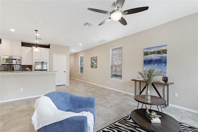 Living room featuring a ceiling fan and recessed lighting