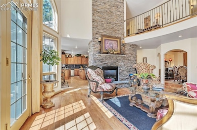 Living room with a stone fireplace, a towering cei