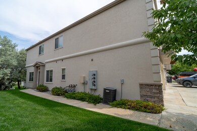 Rear view of property featuring stucco siding and a yard