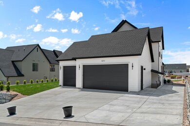 View of front of house featuring a shingled roof, concrete driveway, and a garage