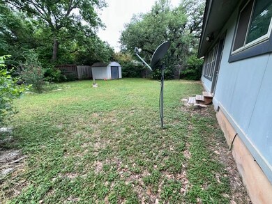 View of yard featuring entry steps, a shed, an ou