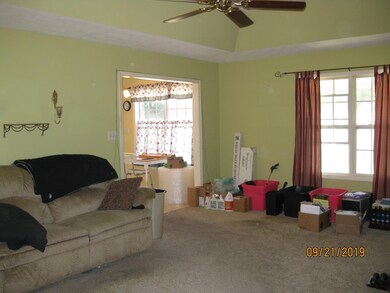 Living room with tray ceiling and ceiling fan