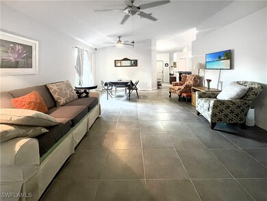 Living area featuring ceiling fan, dark tile patte