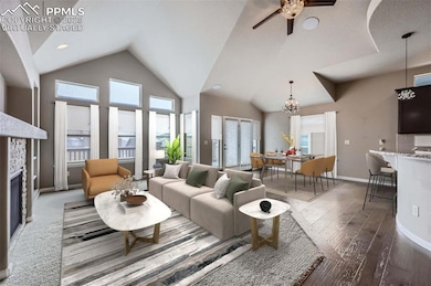 Virtually Staged. Living room with a fireplace, ceiling fan with notable chandelier, a high ceiling, and dark hardwood / wood-style floors