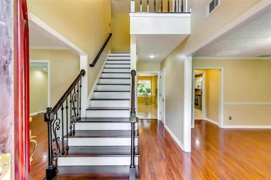 Stairs with wood finished floors and ornamental molding