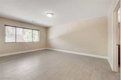 Unfurnished room with baseboards and light wood-st