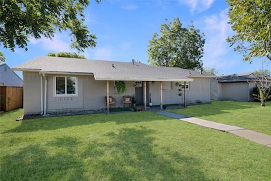 Ranch-style home with a shingled roof, a porch, and brick siding