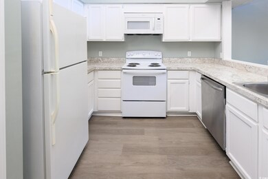 Kitchen featuring white cabinetry, light hardwood 