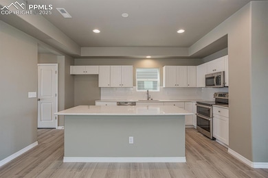 Kitchen with tasteful backsplash, a kitchen island