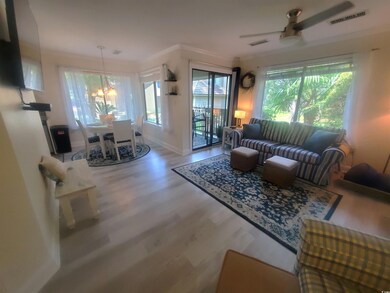 Living area with ceiling fan, wood finished floors, and crown molding