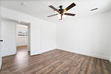 Spare room with wood finished floors, a ceiling fa