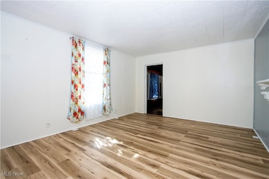 Spare room featuring wood finished floors and ornamental molding