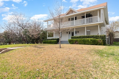 View of front of property featuring covered porch and a front yard