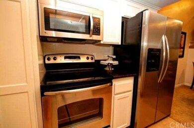 View of pantry, newer oven/range combo, microwave 