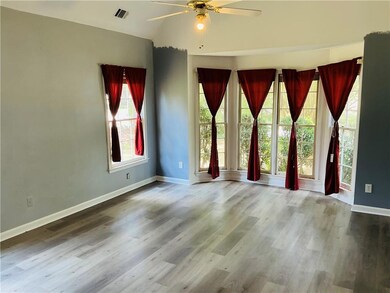 Spare room with a ceiling fan, wood finished floors, and lofted ceiling
