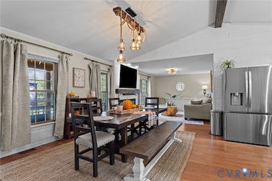 Dining space with wood finished floors and a fireplace