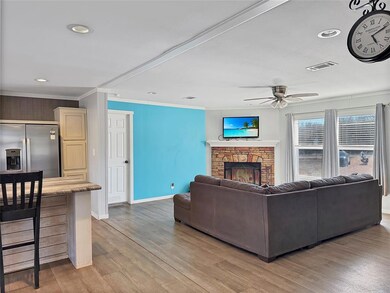 Living room featuring a ceiling fan, a stone firep