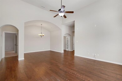 Unfurnished living room with arched walkways, ceil