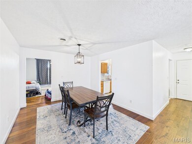 Dining space featuring dark wood-type flooring and a textured ceiling