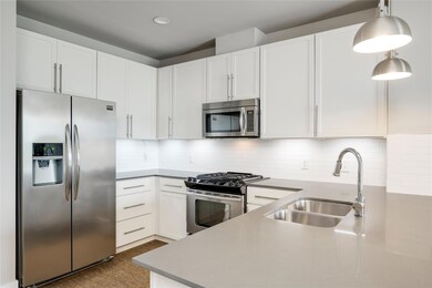 Kitchen featuring appliances with stainless steel finishes, a sink, white cabinets, backsplash, and recessed lighting