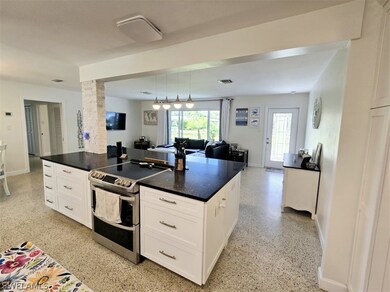 Kitchen with pendant lighting, white cabinets, a k