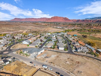 Aerial view of property and surrounding area featuring a mountainous background and nearby suburban area